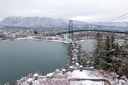 A View of Lions Gate Bridge and West Vancouver covered in snow with mountains in the background. Snow storm and extreme weather in Vancouver.