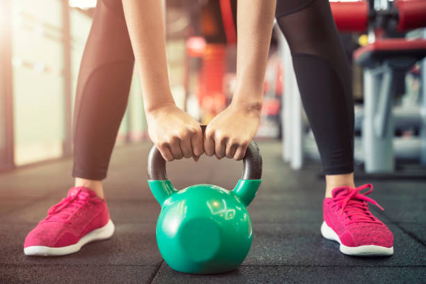 Closeup of people exercise with kettlebell at gym. Sport workout and fitness. Closeup of people exercise with kettlebell at gym. Sport workout and fitness. kettlebell stock pictures, royalty-free photos & images