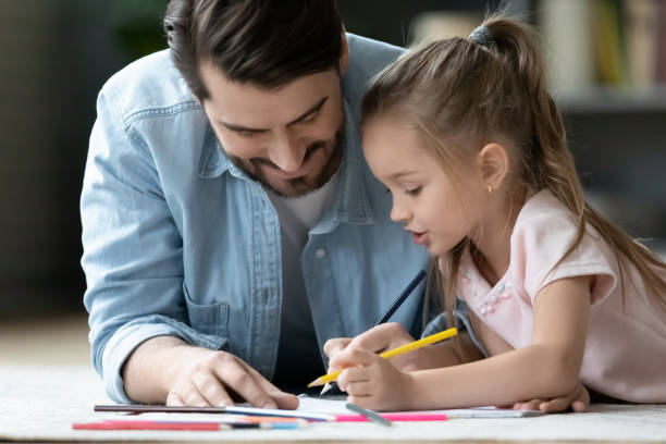 istock Caring dad drawing in album with little daughter 1212315836