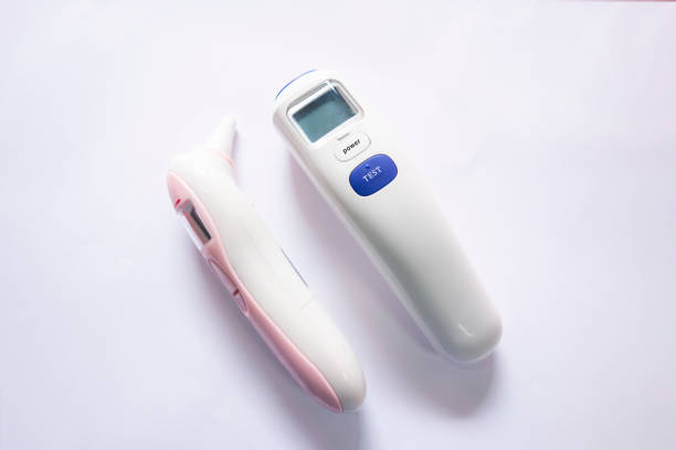 n the white background, there are frontal and ear temperature guns