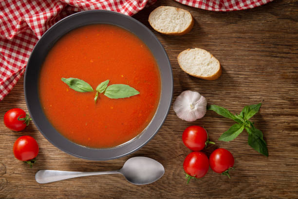 istock bowl of tomato soup with basil on wooden table 1212319075