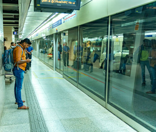 Delhi metro train This image shows man waiting to board delhi metro train at new delhi metro station. The pic is taken in delhi in feb 2020. delhi metro stock pictures, royalty-free photos & images