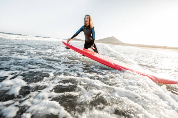 istock Woman surfing in the sea 1212320174