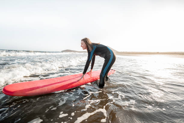 istock Woman surfing in the sea 1212320181