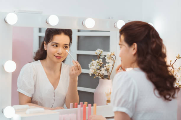 istock A beautiful young woman sitting at a makeup table and doing her makeup. 1212324856