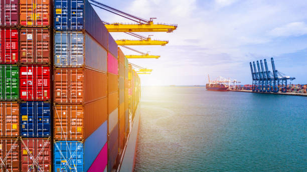 istock Container ship carrying container box in import export with quay crane, Global business cargo freight shipping commercial trade logistic and transportation oversea worldwide by container vessel. 1212324875