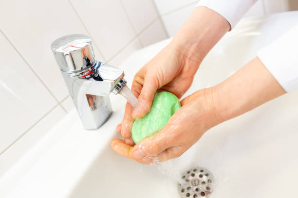 istock a woman washes her hands with soap 1212326873