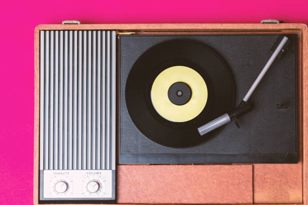 istock Retro vinyl player and record player on a fuchsia background 1212327740