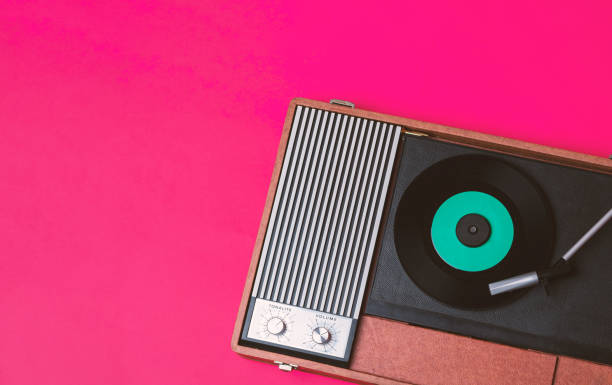 istock Retro vinyl player and gramophone on a fuchsia background 1212327744