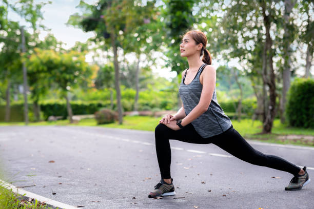 istock Young asian woman runner doing stretch exercise 1212329201