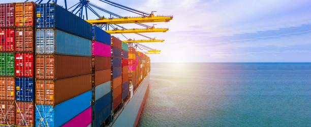 istock Container ship carrying container box in import export with quay crane, Global business cargo freight shipping commercial trade logistic and transportation oversea worldwide by container vessel. 1212330115