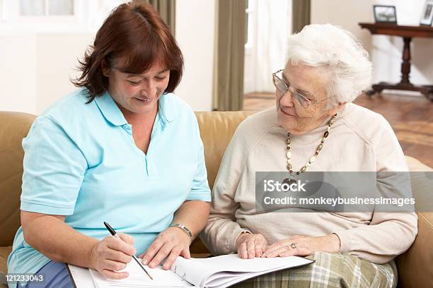 Senior Woman Discussing Health Issues With A Visitor Stock Photo - Download Image Now