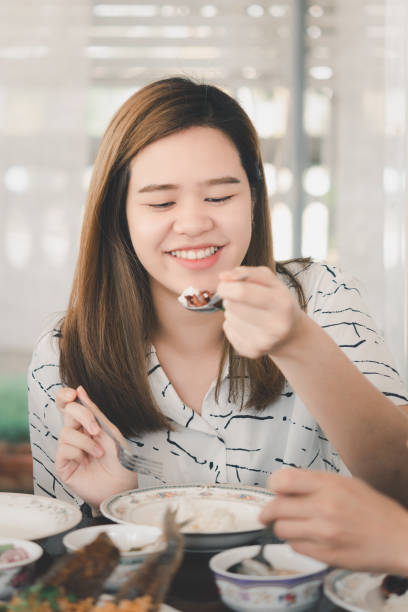 istock Woman eating food on dining table in restaurant 1212335015