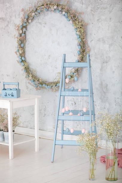Easter holiday. Home decor blue ladder and eggs garland background. Decorative diy wooden symbol. Decorative wooden ladder. Spring room decor. Rustic style. family celebration. Easter colorful eggs vacaciones de pascua. decoración casera escalera azul y huevos guirnalda de fondo. símbolo decorativo de madera. escalera de madera decorativa. decoración de la habitación de primavera. estilo rústico. celebración familiar. huevos de colores de pascu
