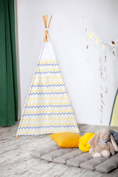 interno della moderna stanza dei bambini con teepee giallo. bambini wigwam casa. interno di elegante camera per bambini con giocattoli. stile scandinavo. camera per bambini con una tenda tipi da gioco splendidamente decorata. - domestic room child furniture nobody foto e immagini stock