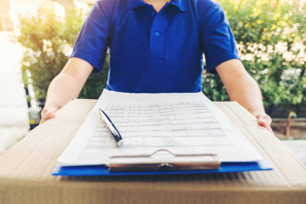 delivery asian man service with boxes in hands standing in front of customer's house doors - postal worker truck driver delivering delivery person imagens e fotografias de stock