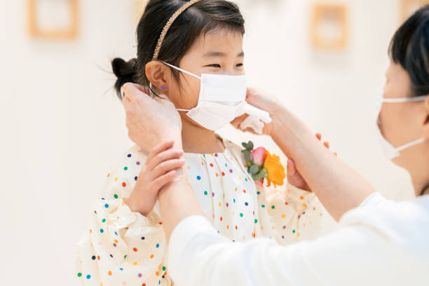 istock Mother putting protective mask on her daughter`s face 1212339657