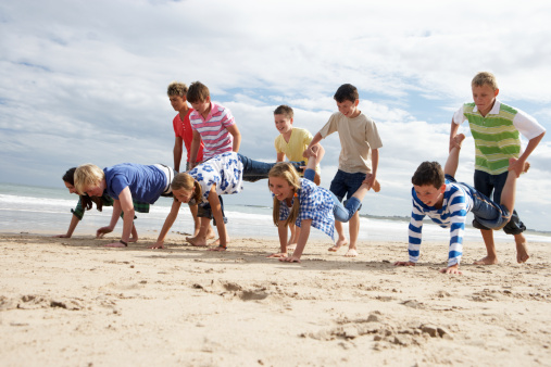 Kids are playing on the beach. Summer time with friends. Beach, sea and summer concept.