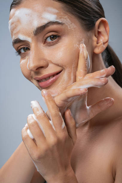 istock Beautiful lady washing her face with hands by soap 1212344356