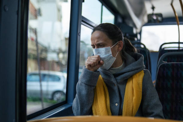 istock Coronavirus protection. Woman coughing with a protective face mask while traveling in bus. 1212345012