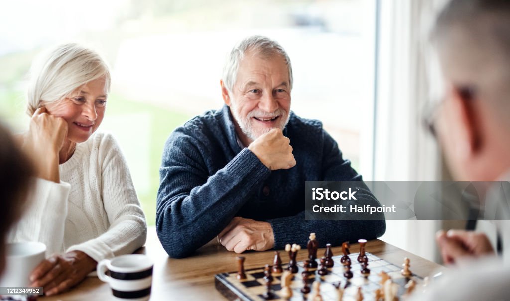Group of senior friends at home, playing board games. Group of happy senior friends at home, playing board games. Senior Adult Stock Photo