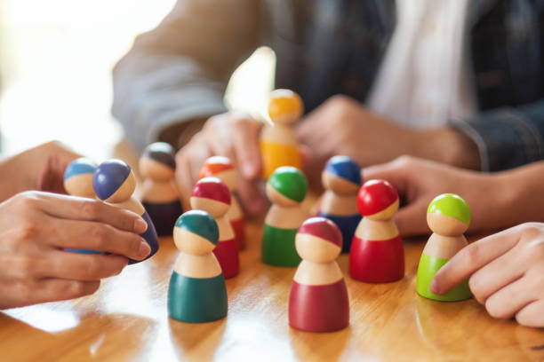 istock People choosing and picking up wooden figure from a group 1212350876