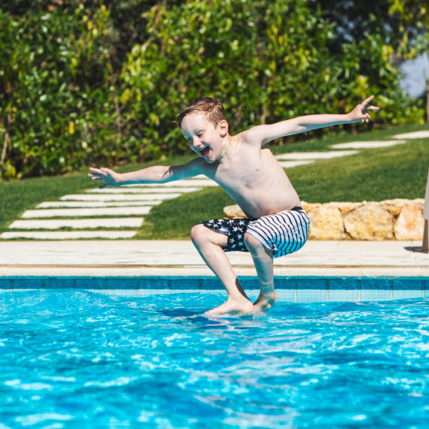 istock boy jumping in swimming pool 1212351967