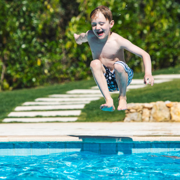 istock boy jumping in swimming pool 1212351977