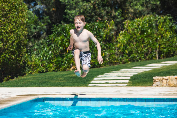 istock boy jumping in swimming pool 1212351986