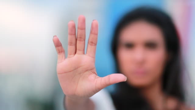 Defensive black woman with her hand extended signaling to stop