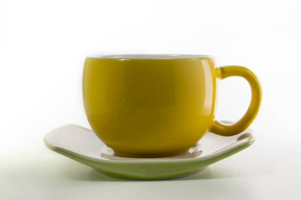 istock Yellow cup with saucer in the white background 1212355404