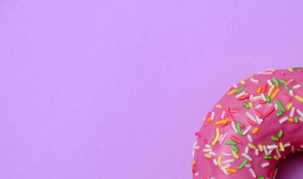 istock sweet donut glaze on a purple background 1212356703