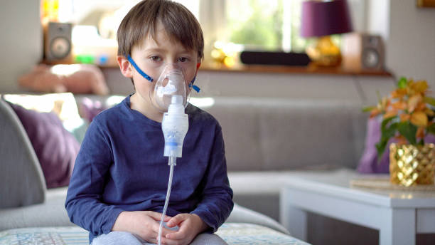 Little boy in the inhalation mask with breathing troubles Little boy in the inhalation mask with breathing troubles at home. respiratory disease stock pictures, royalty-free photos & images