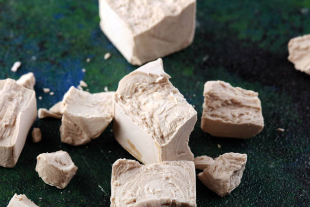 istock Dry yeast crumbled and yeast block for baking on background 1212359635