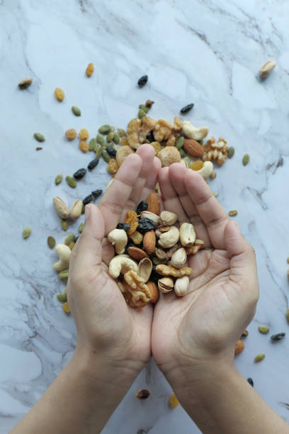 istock top view of mixed nut on women hand 1212365922