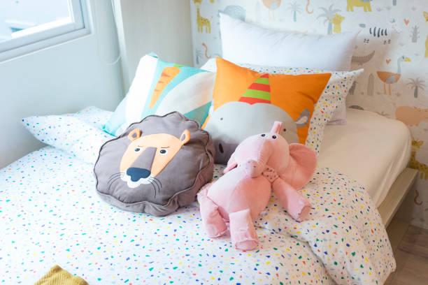 istock Cute plush doll on warm bed in children bedroom. 1212366991