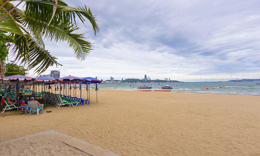 Pattaya, Thailand - August 30, 2019: Panoramic view of Pattaya beach with tourist walking on the shore in Pattaya, Thailand on August 30, 2019.
