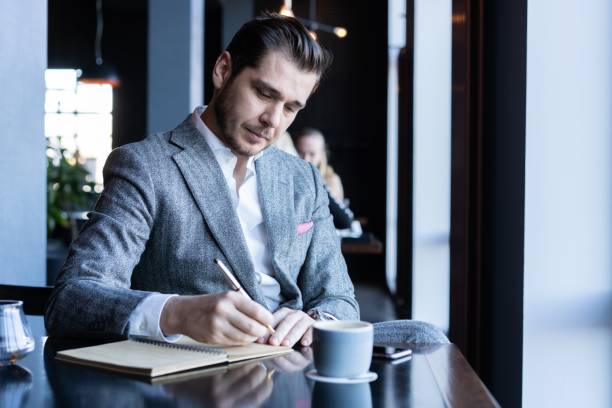 istock business man thinks looks out the window, cafe, documents, cup of coffee 1212368182