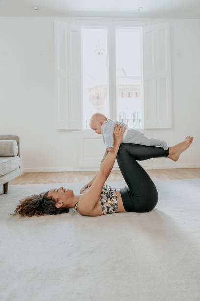 istock Woman exercising at home with baby 1212371326