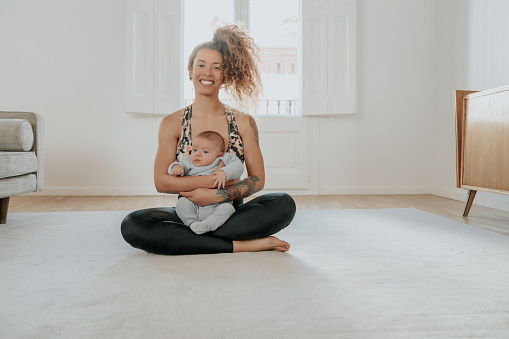 Woman exercising at home with baby