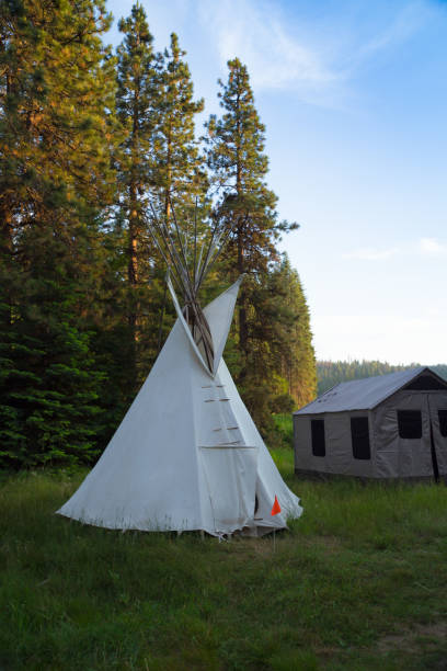 istock A white Indian tent and a canvas tent set up in meadow Surround by pine forest 1212371548