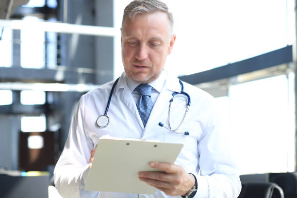 istock Portrait of focused senior doctor writing reports. 1212371658