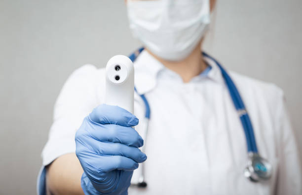 istock Doctor pointing infrared thermometer gun to check body temperature epidemic virus outbreak concept 1212374804