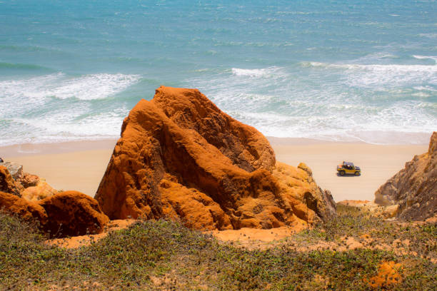 istock Car on the shore between the cliffs with the beach in the background 1212376506