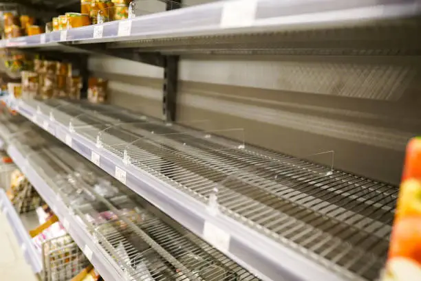 Many empty shelves with few canned goods left in a Eurpean supermarket because of panic shopping because of Covid-19 virus