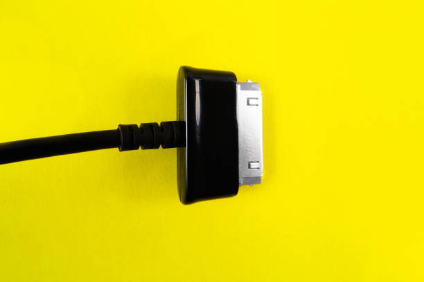 istock black socet for tablet on a yellow background. Top view 1212378294