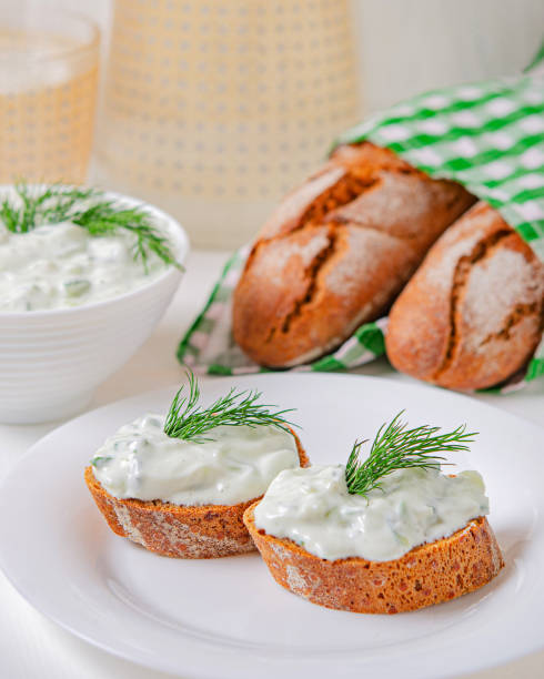 istock Greek appetizer (salad) - tzatziki. Yogurt, fresh cucumbers and dark (buckwheat) bread (baguette). 1212379233