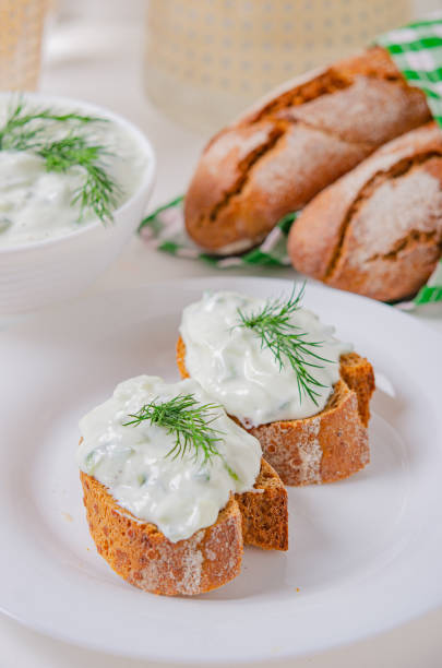 istock Greek appetizer (salad) - tzatziki. Yogurt, fresh cucumbers and dark (buckwheat) bread (baguette). 1212379260