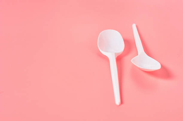 istock Two white disposable spoons on pink background. Concept of save environment, ecology, recreation on picnic, party and other events. Copy space 1212380410