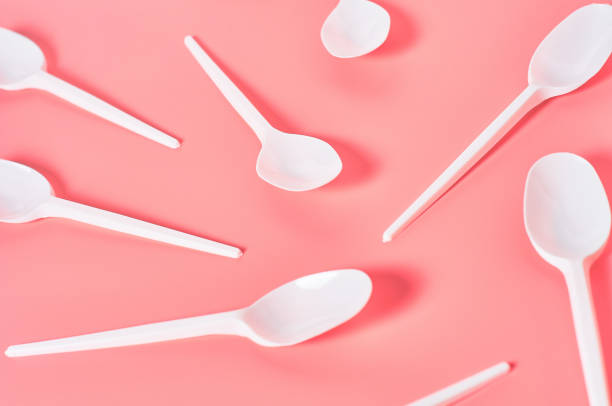 istock White disposable spoons scattered on pink background. Concept of save environment, ecology, recreation on picnic, party and other events 1212380415